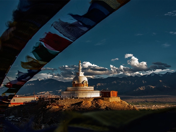 Shanti Stupa in Leh Ladakh with Himalayan mountains and Buddhist prayer flags